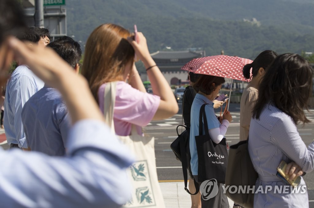 폭염에 햇볕 가리는 시민들