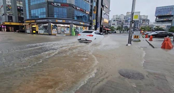 18일 충남 서산에서 집중호우에 침수된 도로를 달리는 차량 <사진=연합뉴스>