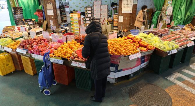 설 명절을 앞두고 이상기후 여파 등으로 차례상 비용이 상승한 가운데 13일 서울 시내 한 전통시장에서 이용객들이 과일 등 농산물을 살펴보고 있다. <사진=연합뉴스>