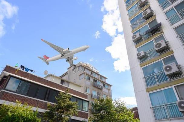 공항소음피해지역 주택 위로 지나가는 비행기 <사진=연합뉴스>